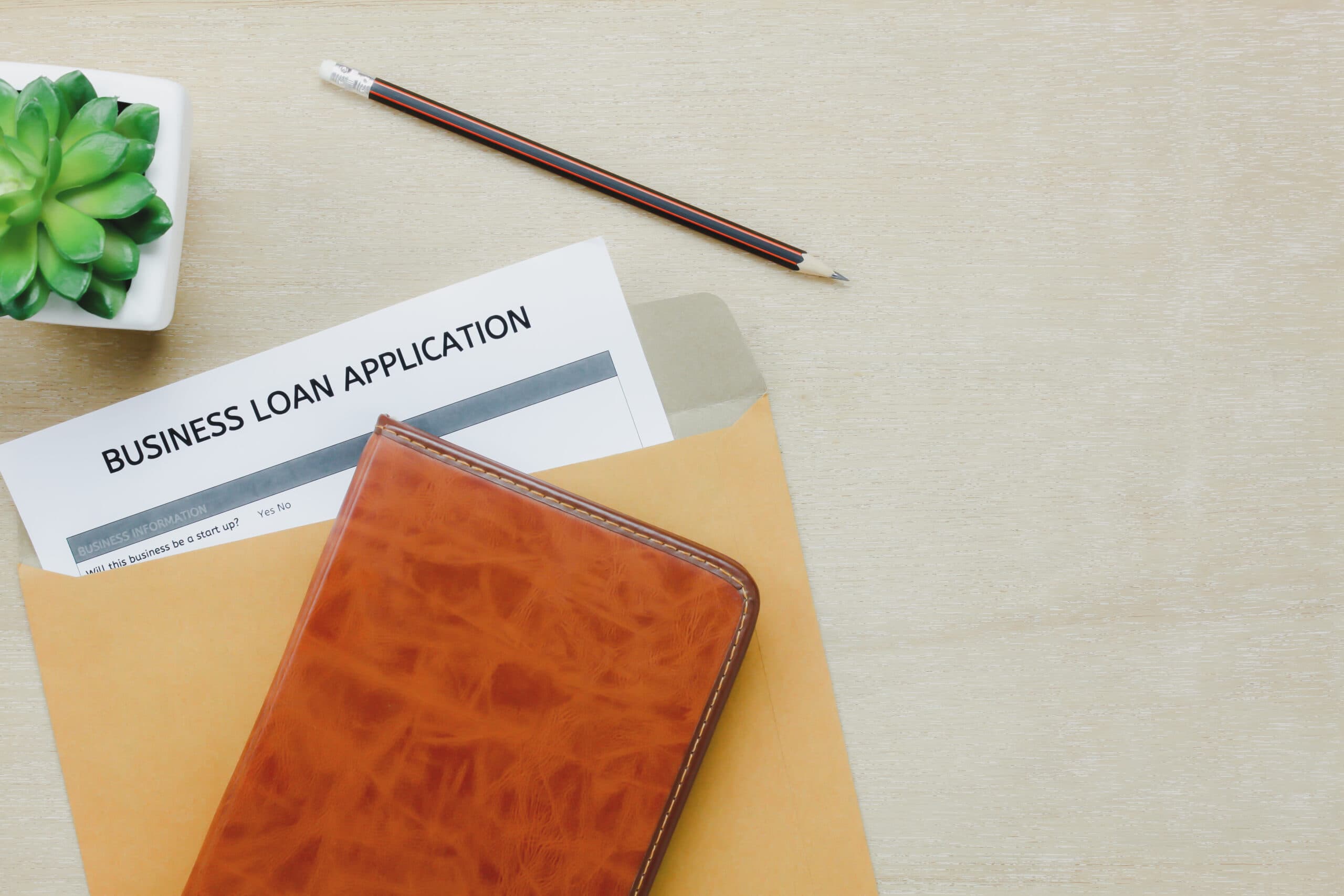 top-view-business-office-desk-background-business-loan-appcation-form-pencil-letter-diary-tree-wooden-table-background-with-copy-space-scaled